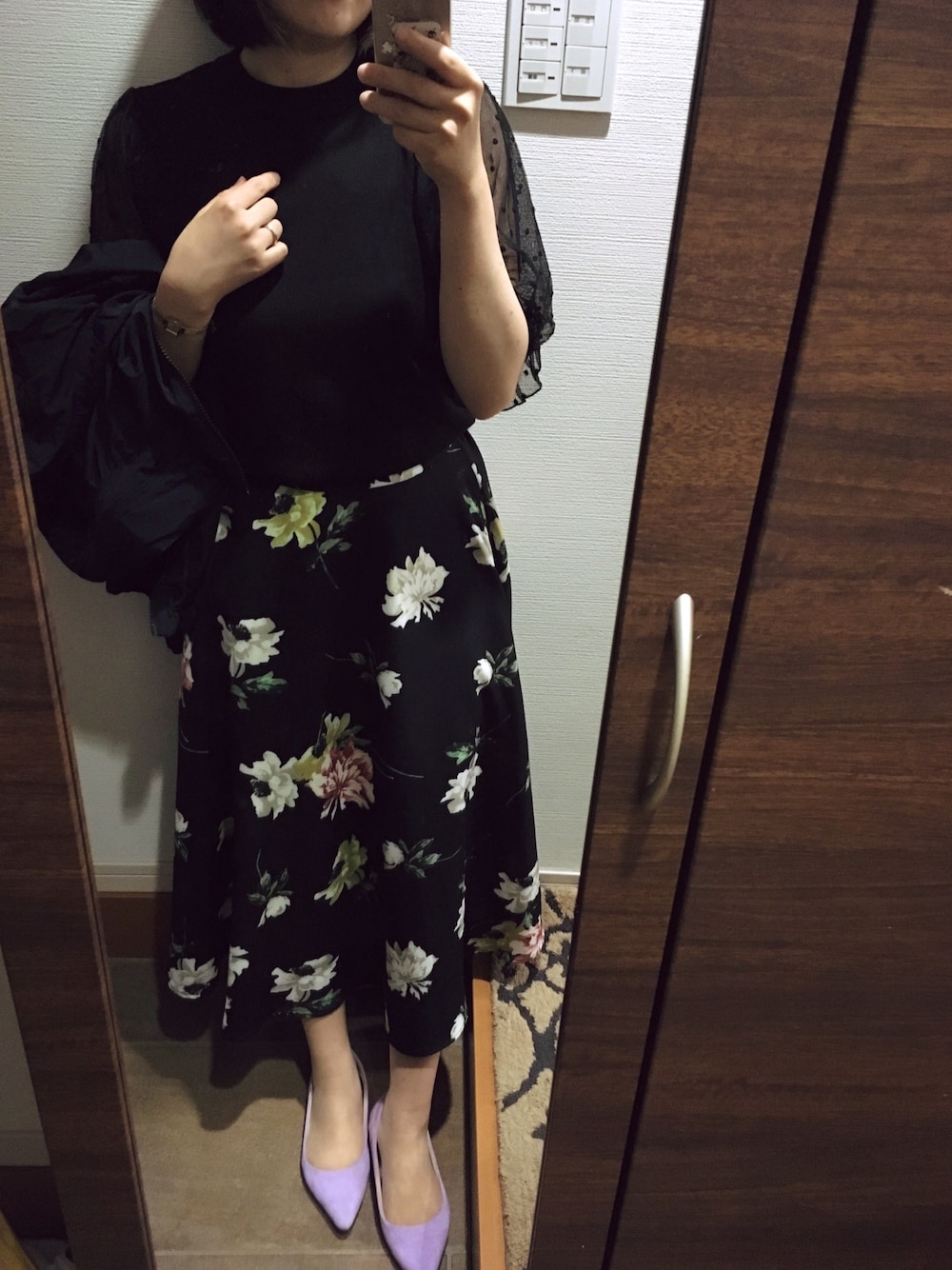 ブラック系のスカート、パープル系のパンプス、ブラック系のその他トップスを着用したレディースの春コーディネートの1枚目の写真