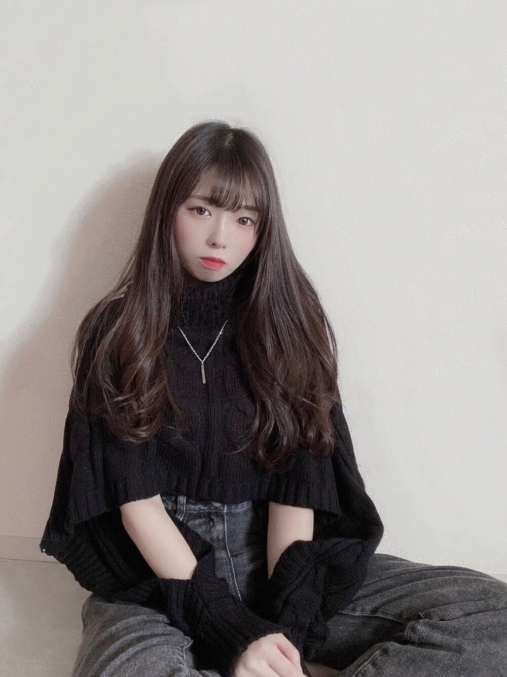 ブラック系のニット/セーター、ブラック系のデニムパンツ、その他のネックレスを着用したレディースの冬コーディネートの1枚目の写真