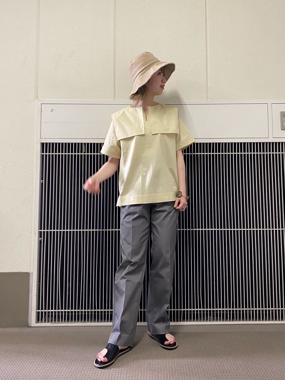 イエロー系のシャツ/ブラウス、グレー系のその他パンツ、ベージュ系のハットを着用したレディースの春コーディネートの1枚目の写真