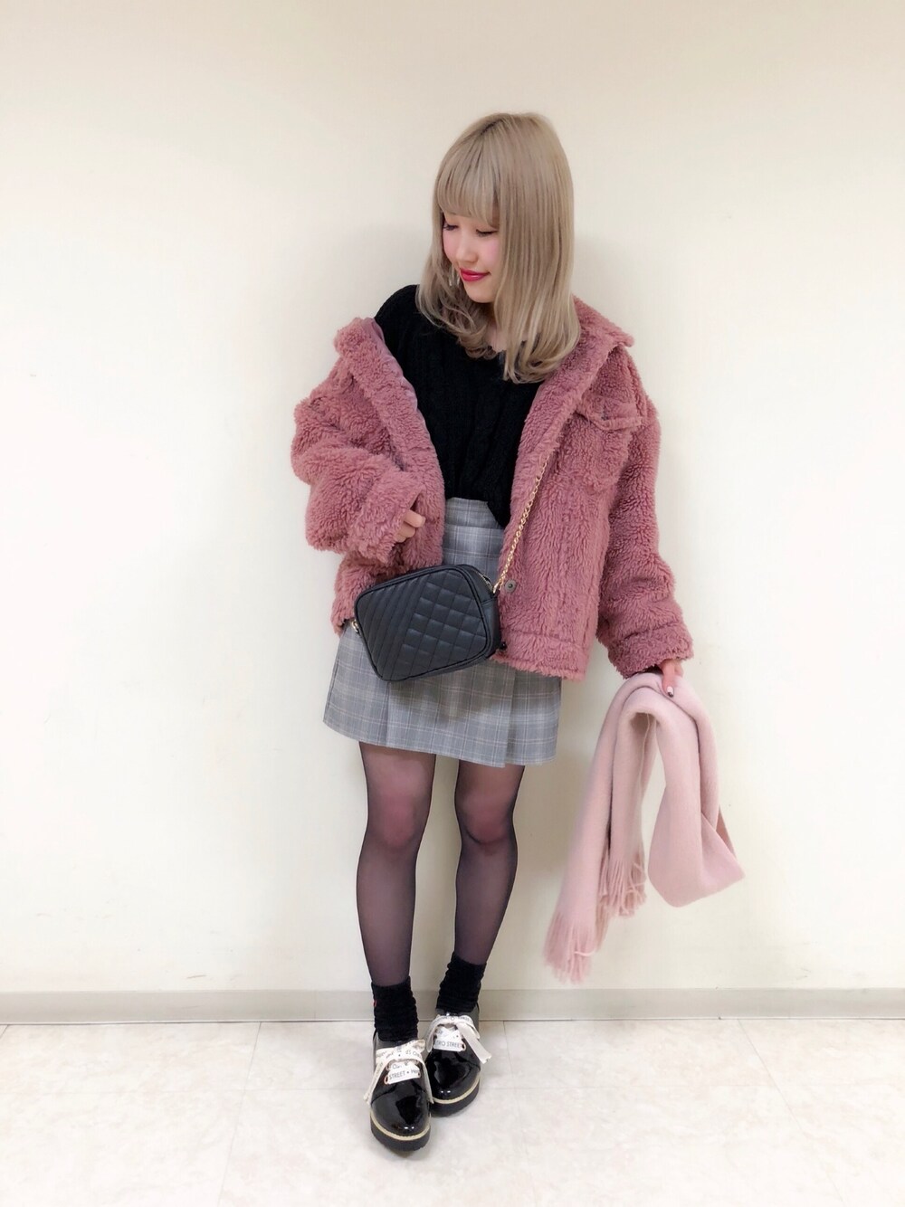 オレンジ系のスカート、ピンク系のブルゾン、ブラック系のニット/セーターを着用したレディースの冬コーディネートの1枚目の写真