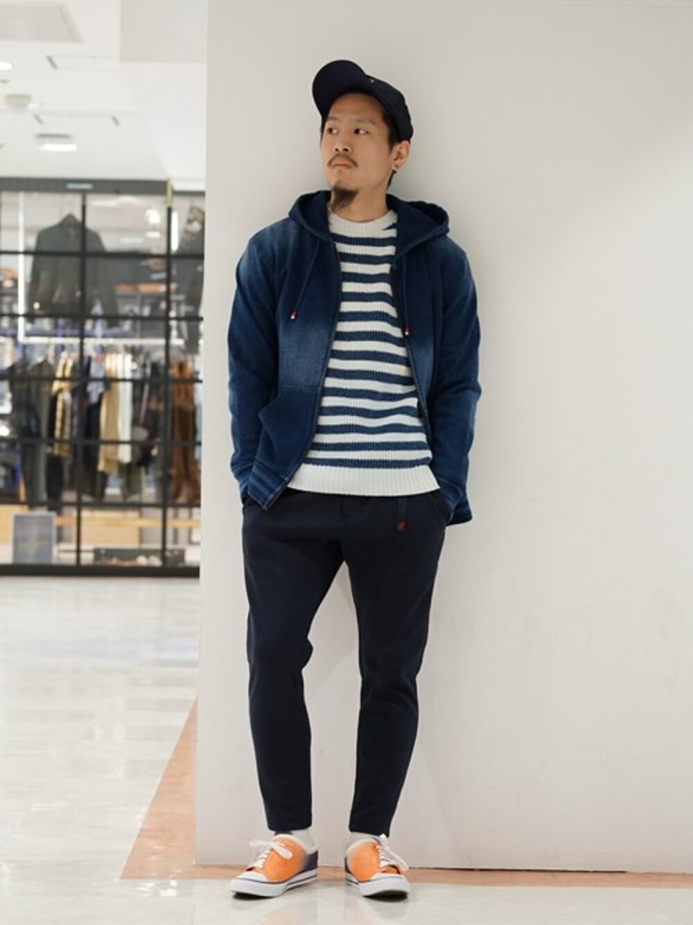 ブルー系のニット/セーター、ブルー系のパーカー、ブルー系のキャップを着用したメンズの春コーディネートの1枚目の写真