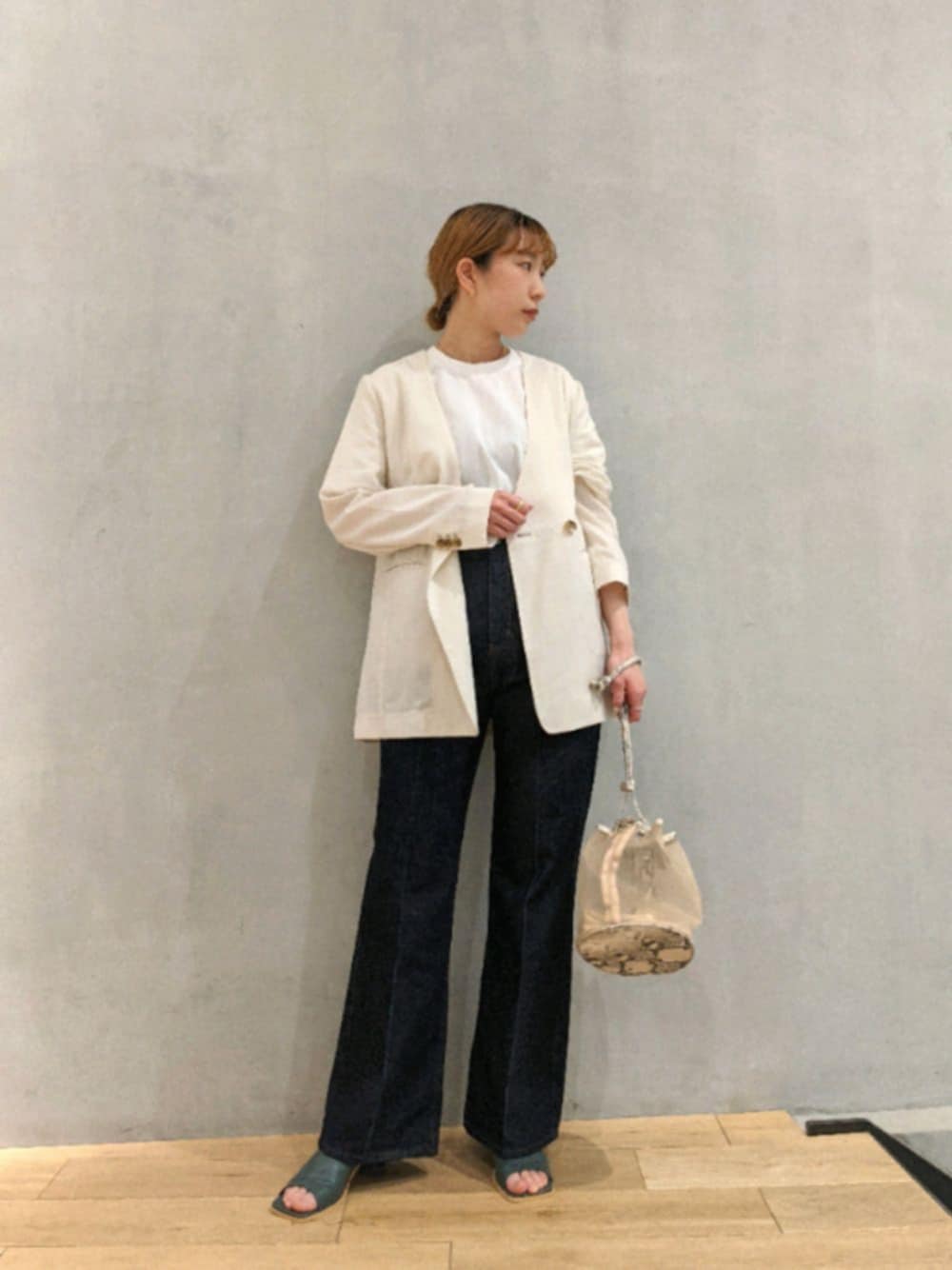 ホワイト系のその他アウター、ブルー系のデニムパンツ、ホワイト系のショルダーバッグを着用したレディースの春コーディネートの1枚目の写真