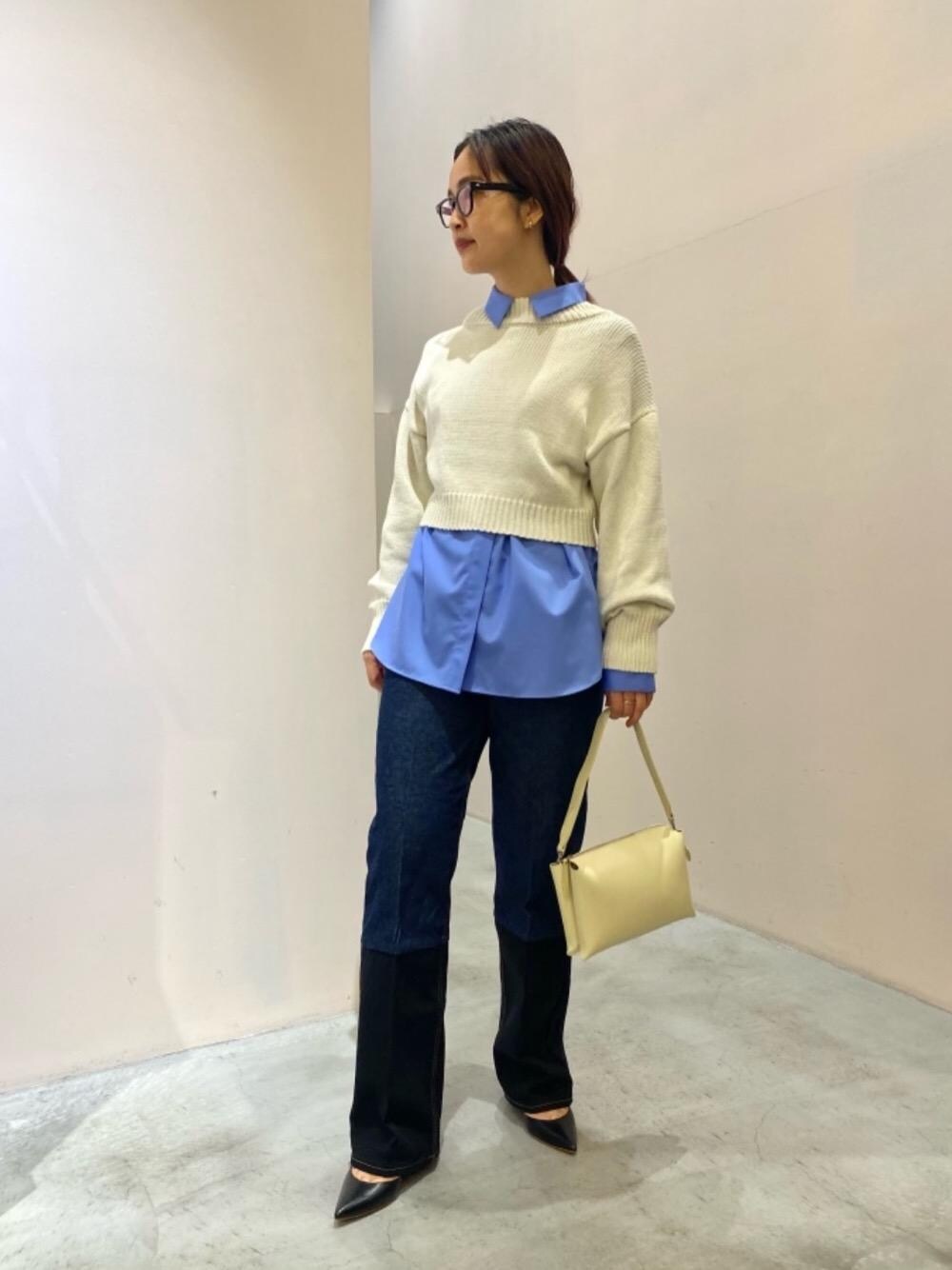 ブラック系のデニムパンツ、ホワイト系のニット/セーター、ベージュ系のショルダーバッグを着用したレディースの冬コーディネートの1枚目の写真
