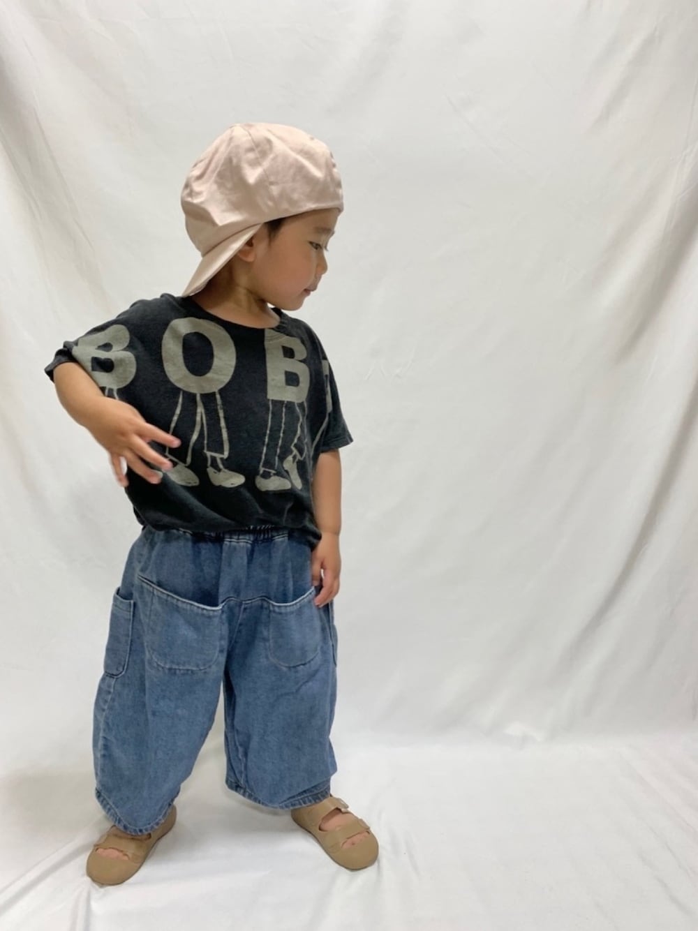 ブラック系のTシャツ/カットソー、ブルー系のデニムパンツ、ベージュ系のサンダルを着用したキッズの夏コーディネートの1枚目の写真