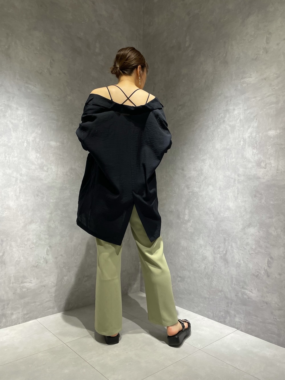 ブラック系のテーラードジャケット、グリーン系のスラックス、ブラック系のサンダルを着用したレディースの夏コーディネートの1枚目の写真