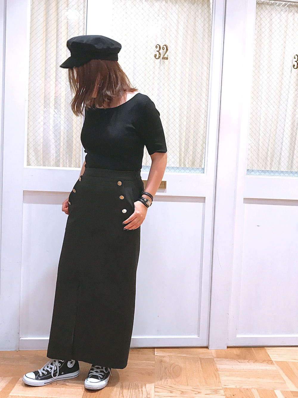 ブラック系のスカート、ブラック系のスニーカー、ブラック系のニット/セーターを着用したレディースの夏コーディネートの1枚目の写真