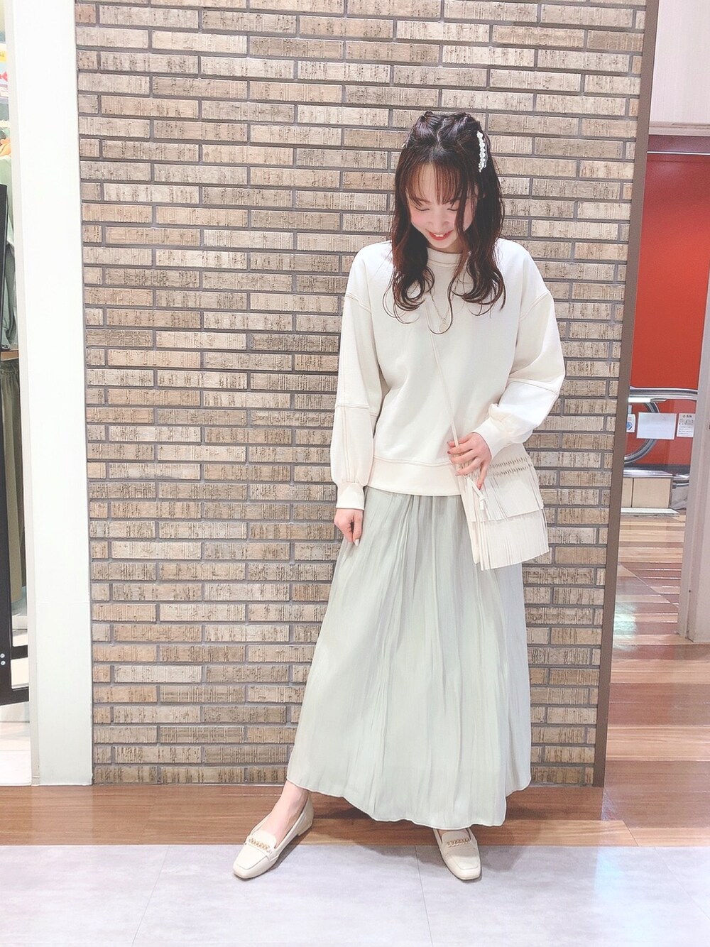 ホワイト系のTシャツ/カットソー、グリーン系のスカート、ホワイト系のドレスシューズを着用したレディースの冬コーディネートの1枚目の写真