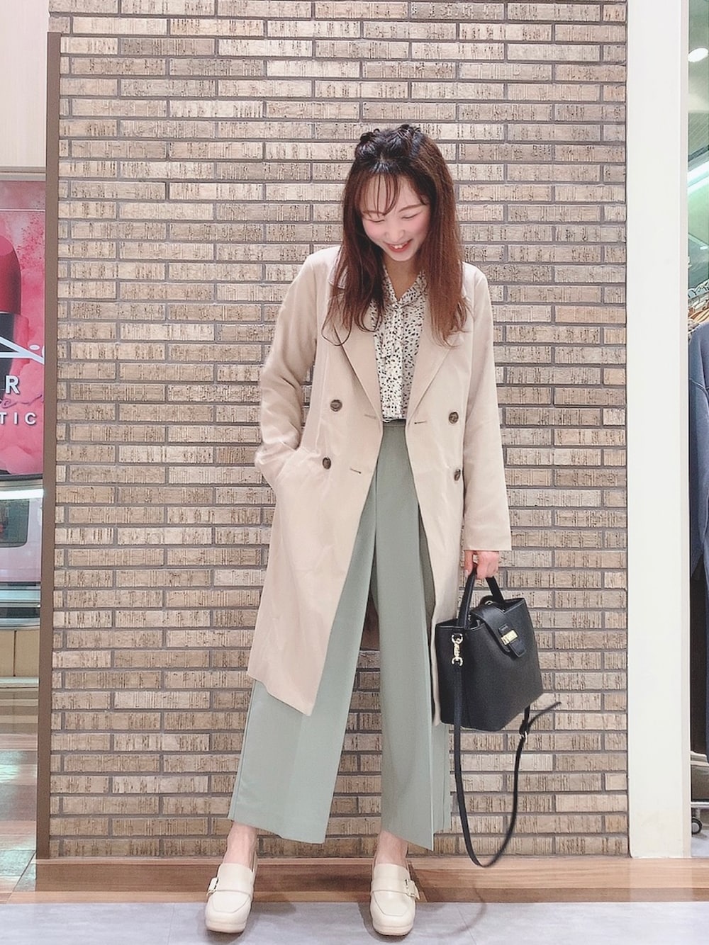 ベージュ系のトレンチコート、グリーン系のその他パンツ、ホワイト系のドレスシューズを着用したレディースの春コーディネートの1枚目の写真