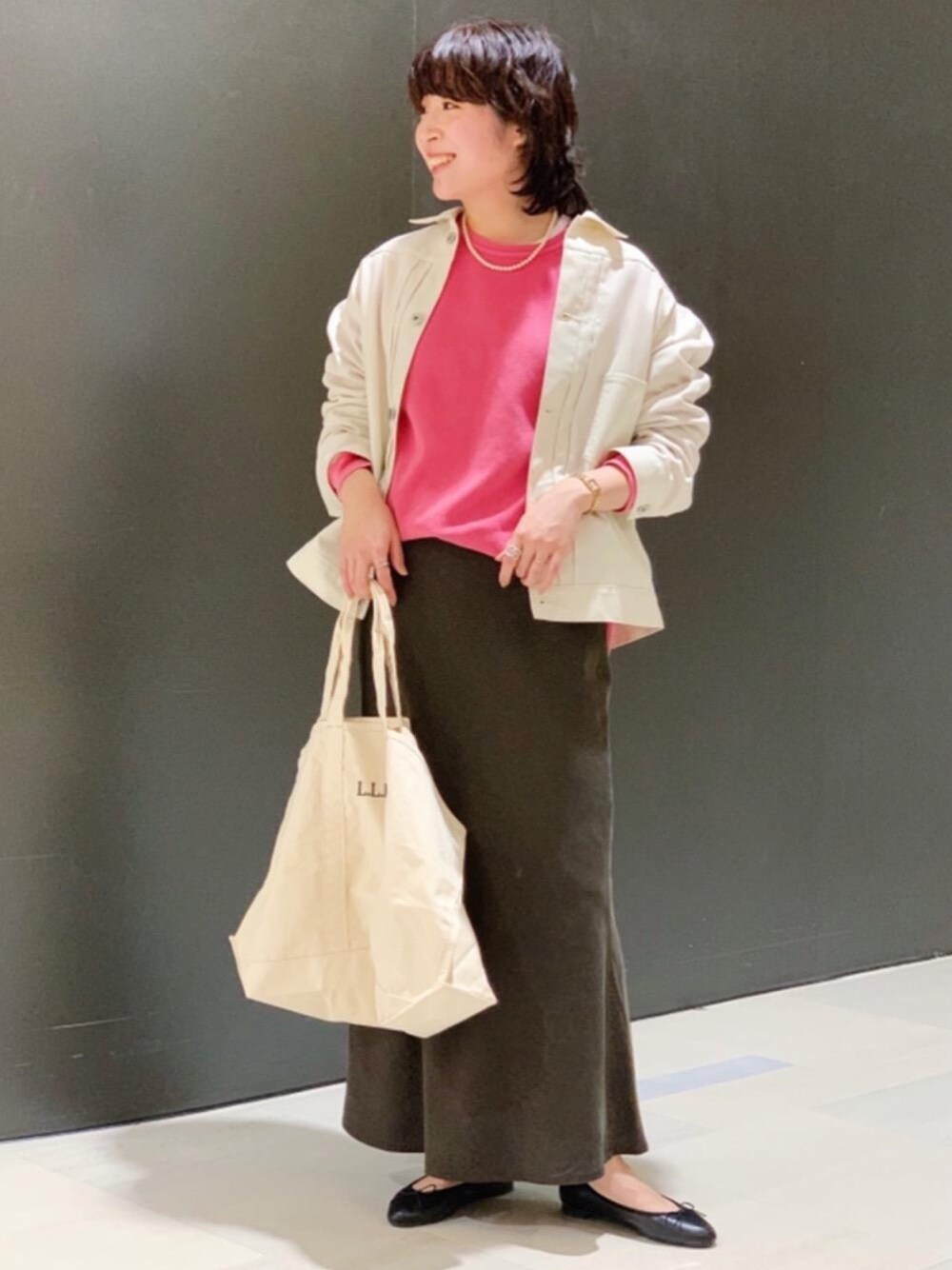 ホワイト系のトートバッグ、ブラック系のスカート、ホワイト系のその他アウターを着用したレディースの冬コーディネートの1枚目の写真