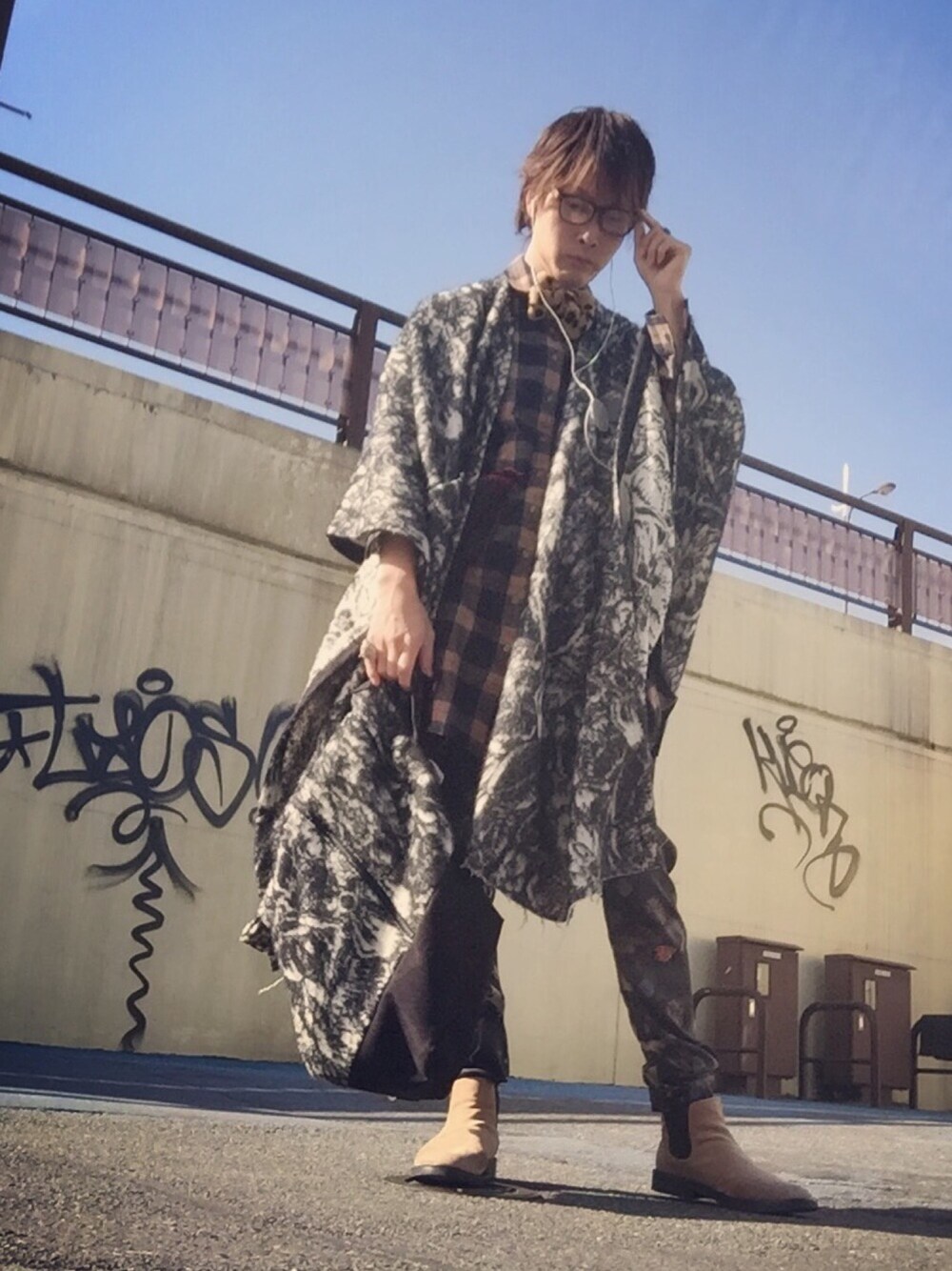 ブラック系のポンチョ、ベージュ系のワンピース、ブラック系のその他パンツを着用したメンズの冬コーディネートの1枚目の写真