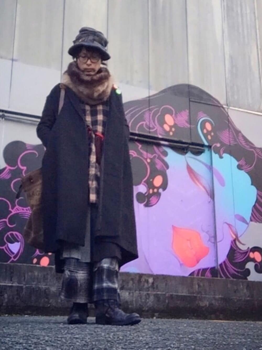 ベージュ系のワンピース、ブラック系のチェスターコート、ブラック系のスカートを着用したメンズの冬コーディネートの1枚目の写真