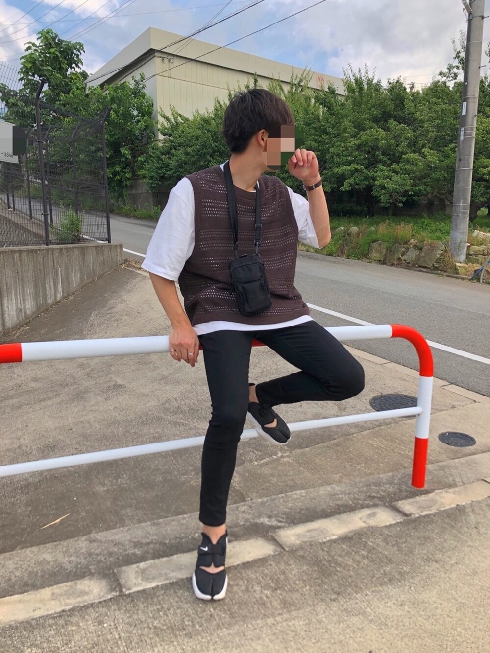 ブラック系のデニムパンツ、ブラック系のサンダル、ブラウン系のベストを着用したメンズの夏コーディネートの1枚目の写真