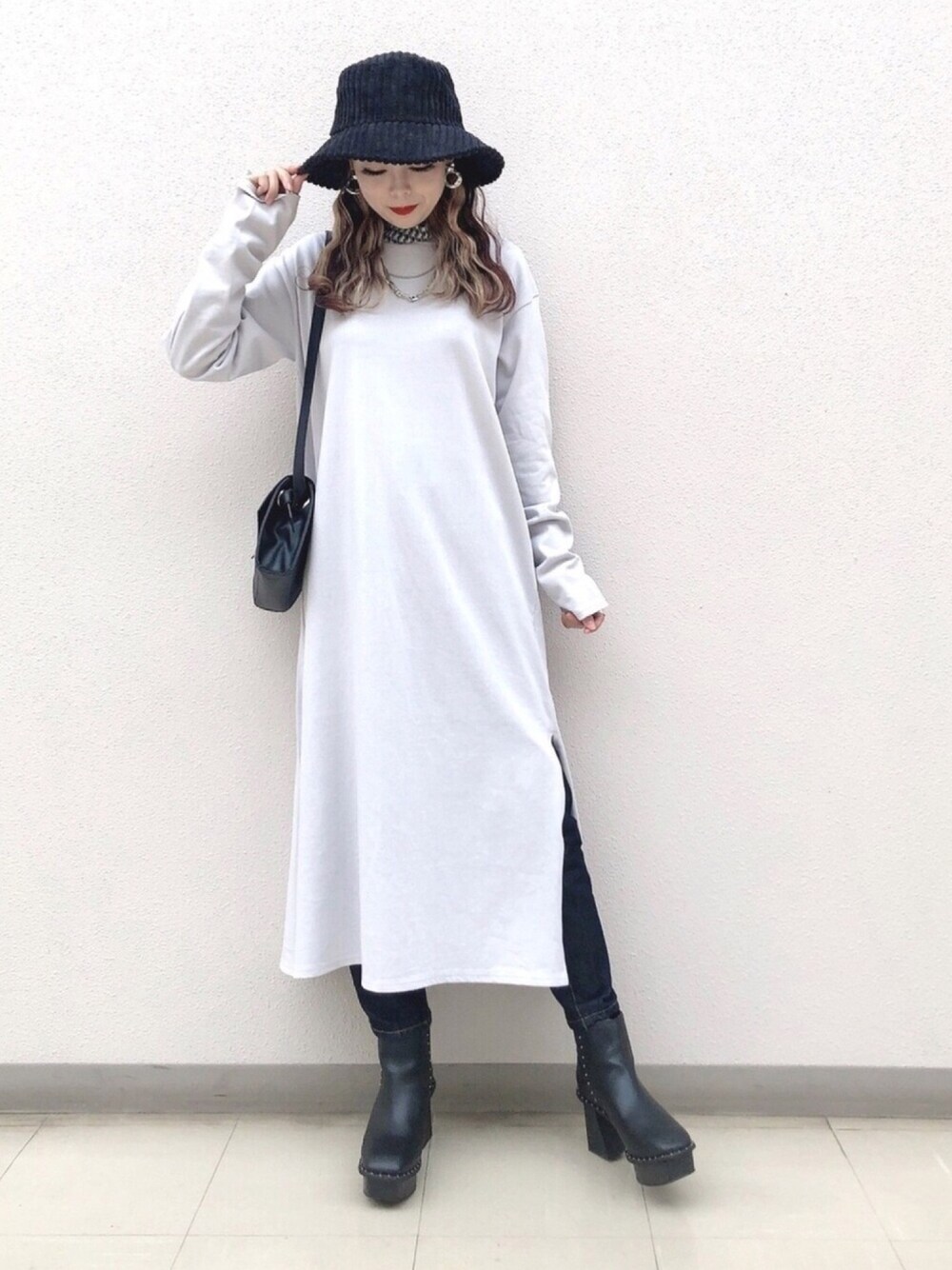 ブラック系のTシャツ/カットソー、ベージュ系のワンピース、ブルー系のデニムパンツを着用したレディースの秋コーディネートの1枚目の写真