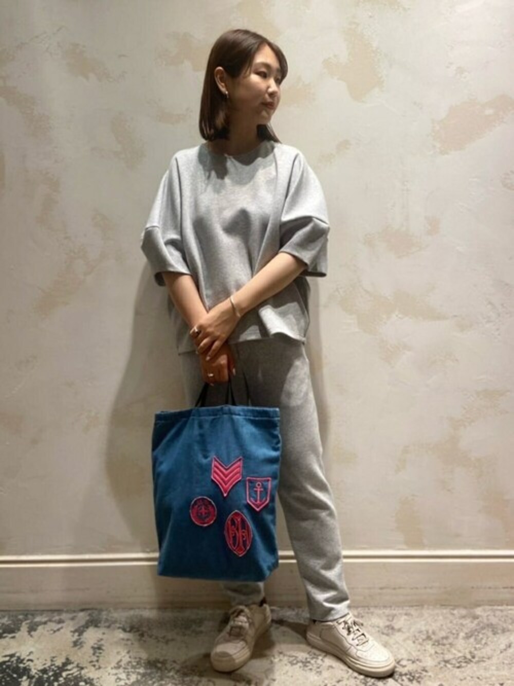 グレー系のTシャツ/カットソー、グレー系のその他パンツ、ブルー系のトートバッグを着用したレディースの秋コーディネートの1枚目の写真