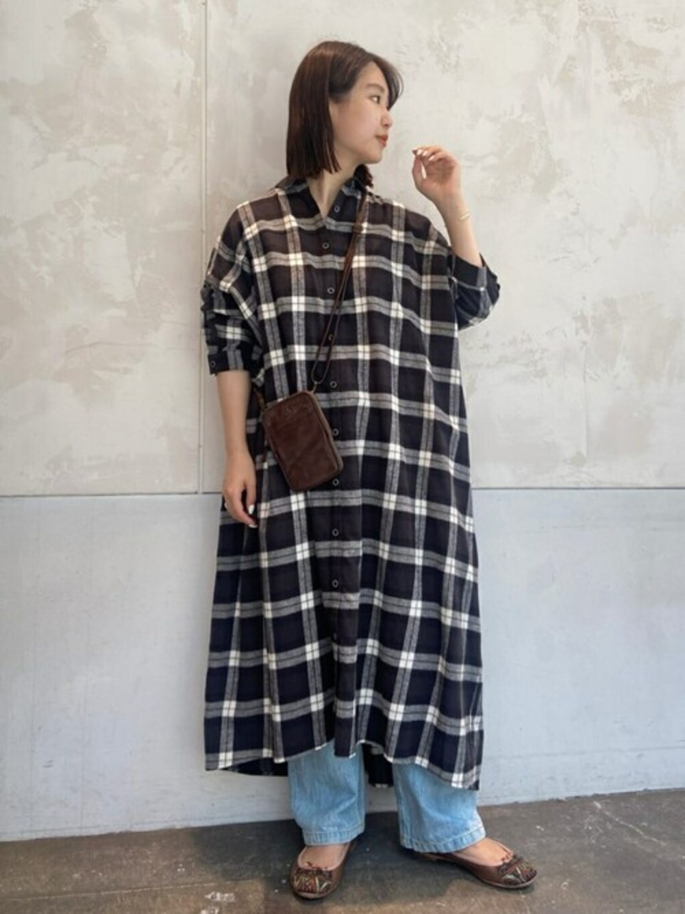 ブラック系のシャツワンピース、イエロー系のトートバッグを着用したレディースの秋コーディネートの1枚目の写真