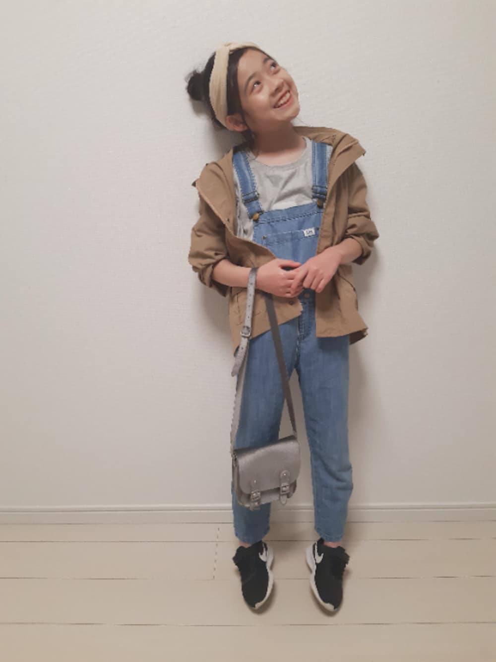 「春コーデ、ブラウン色に染まれ、オーバーオール、デニムサロペット、お団子ヘアー、ヘアバンド、LEE、NIKE、スニーカーコーデ、カジュアルコーデ」｜「apres les coursの/LEE　ママ後布帛ギャザーＴシャツ（Tシャツ/カットソー、グレー系）」を使った、nemoさん（キッズ・135cm）の春コーディネートの1枚目の写真