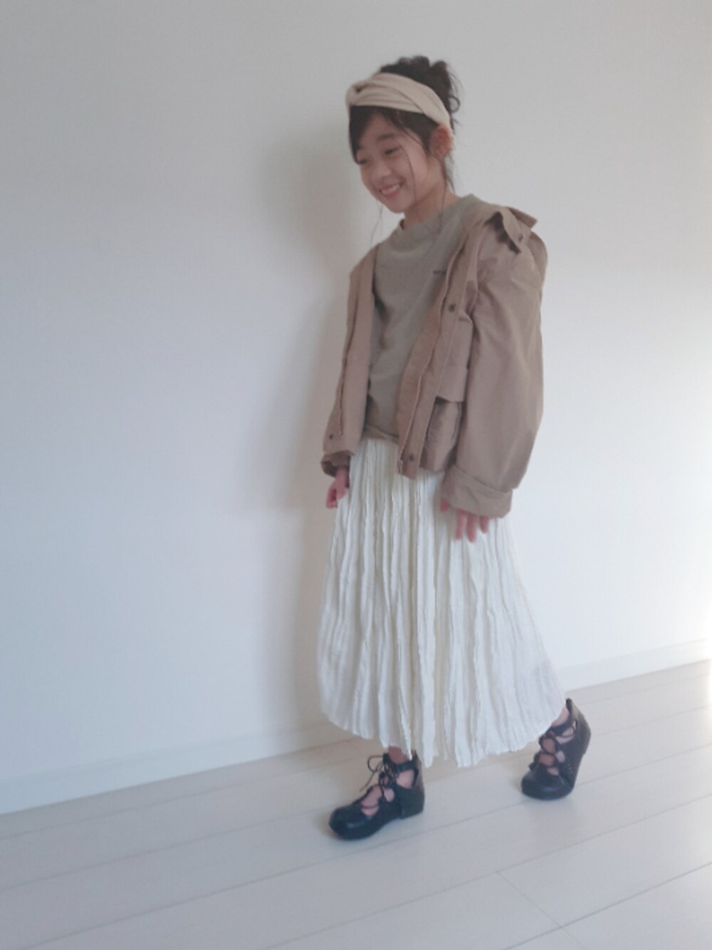 「マウンテンパーカー、ワントーンコーデ、ギャザースカート、プリーツスカート、ヘアバンド、お団子ヘアー、ベージュ、レースアップシューズ、休日スタイル、春コーデ」｜「SOROTTOの(KIDS)レースアップ トドラーシューズ（パンプス、ブラック系）」を使った、nemoさん（キッズ・135cm）の春コーディネートの1枚目の写真