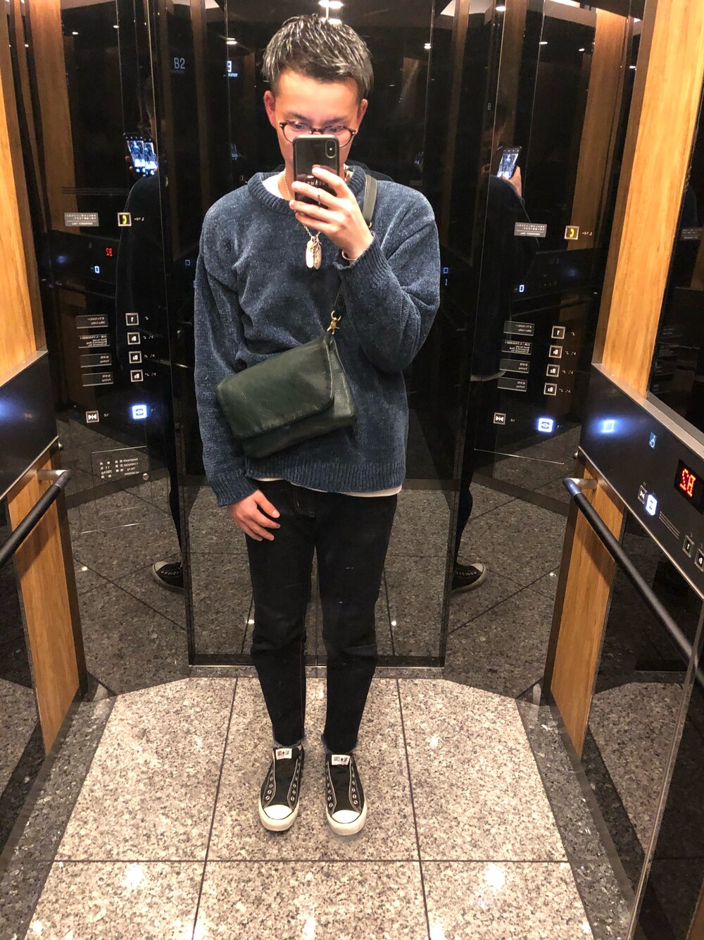 グリーン系のニット/セーター、グリーン系のショルダーバッグ、ブルー系のデニムパンツを着用したメンズの秋コーディネートの1枚目の写真