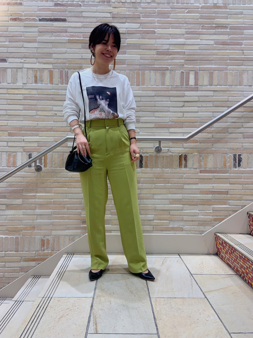 ホワイト系のTシャツ/カットソー、ブラック系のハンドバッグ、ブラック系のパンプスを着用したレディースの秋コーディネートの1枚目の写真