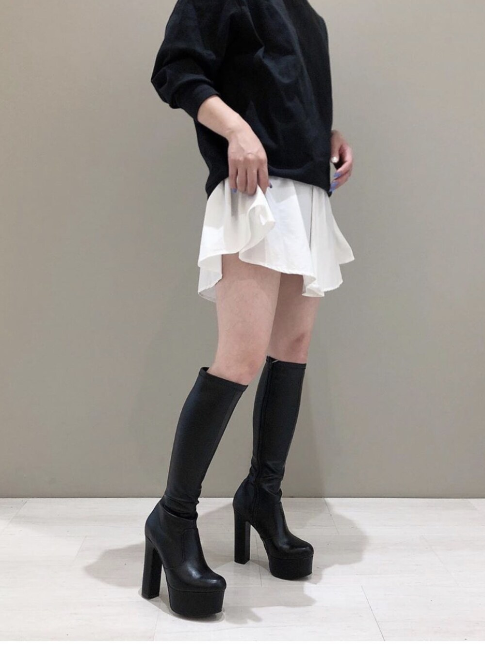 ブラック系のブーツを着用したレディースの秋コーディネートの1枚目の写真