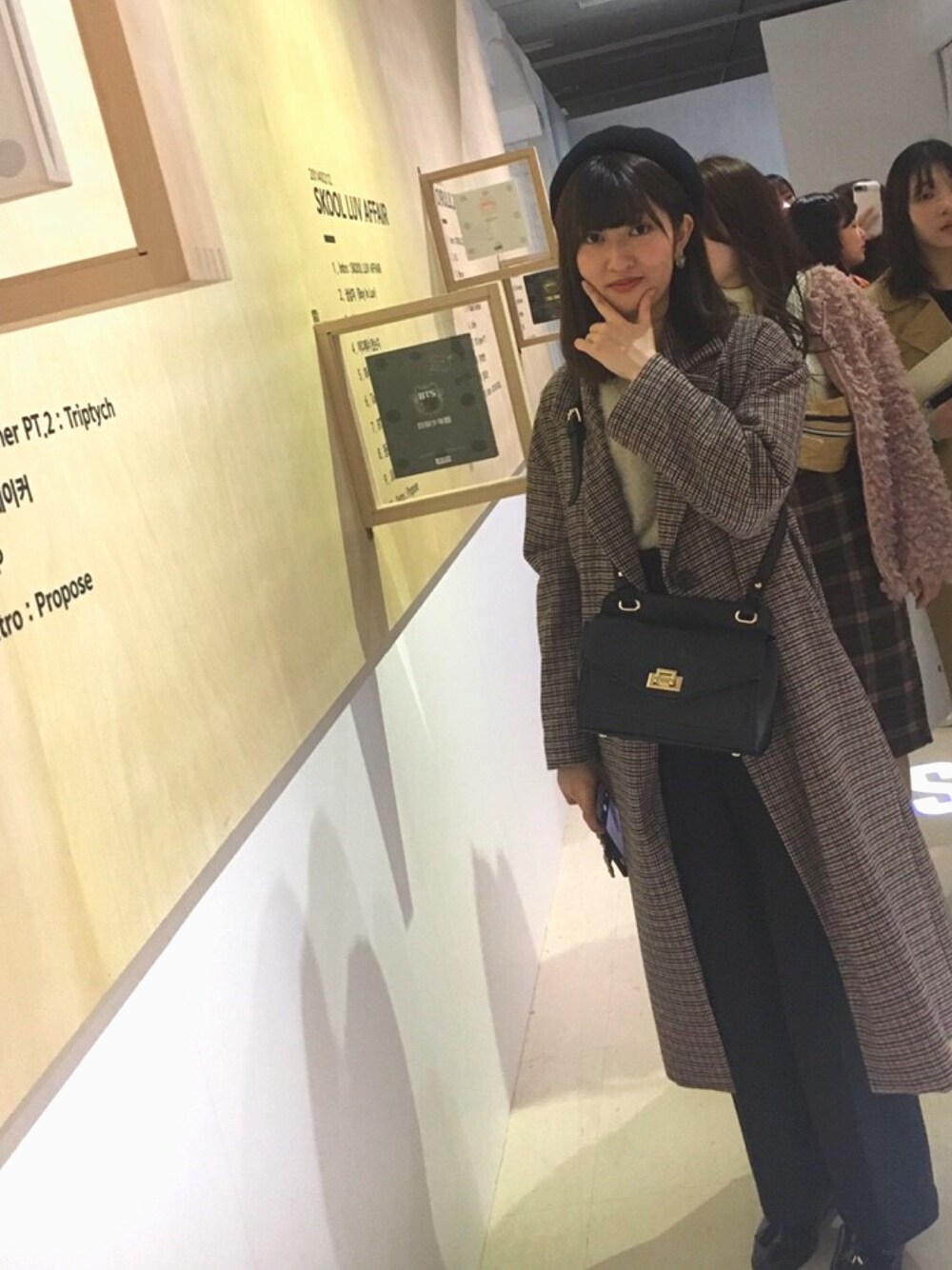 レッド系のチェスターコート、ベージュ系のニット/セーター、ブラック系のその他パンツを着用したレディースの冬コーディネートの1枚目の写真