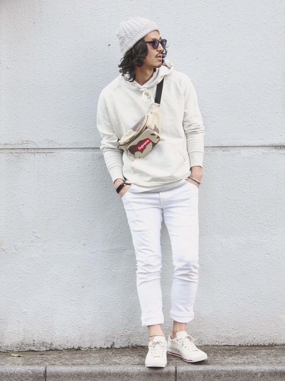 ホワイト系のデニムパンツ、ホワイト系のスニーカー、ホワイト系のパーカーを着用したメンズの春コーディネートの1枚目の写真