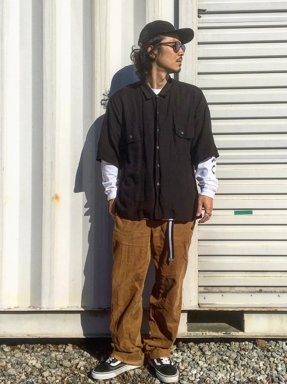 ホワイト系のTシャツ/カットソー、ブラック系のシャツ/ブラウス、ブラウン系のパンツを着用したメンズの秋コーディネートの1枚目の写真
