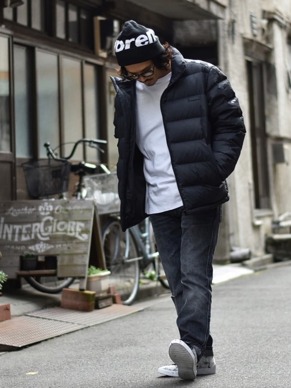 ブラック系のダウンジャケット/コート、ホワイト系のスウェット、グレー系のデニムパンツを着用したメンズの秋コーディネートの1枚目の写真