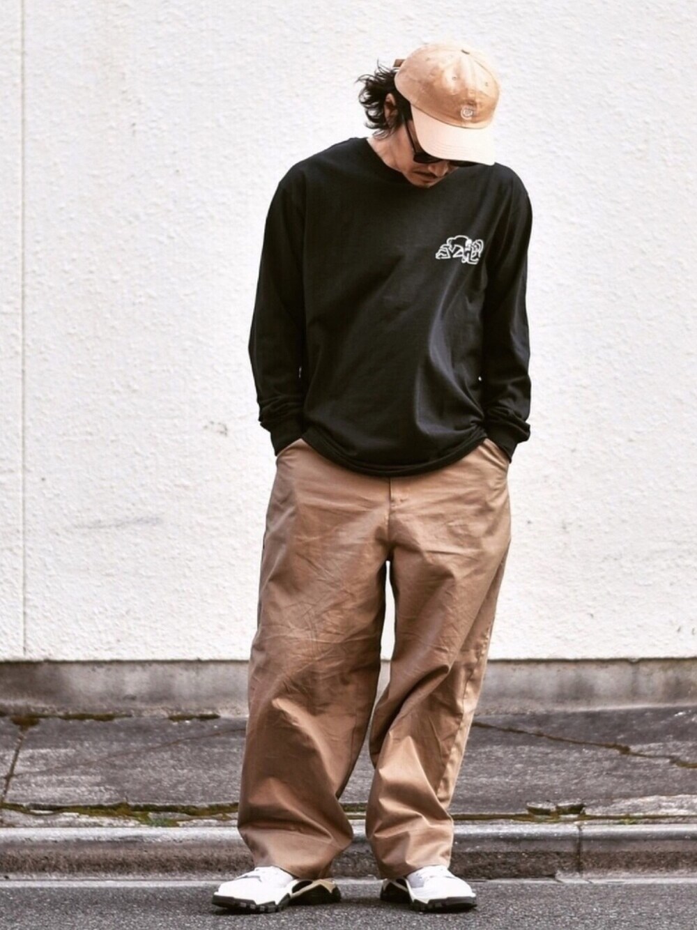 ブラック系のTシャツ/カットソー、ベージュ系のその他パンツ、グレー系のスニーカーを着用したメンズの春コーディネートの1枚目の写真