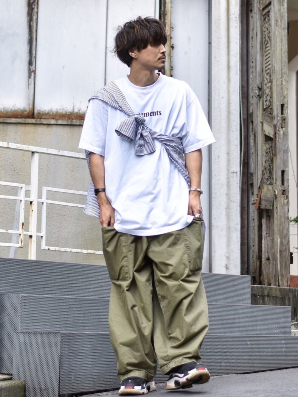 ホワイト系のTシャツ/カットソー、グリーン系のパンツ、ブラック系のスニーカーを着用したメンズの夏コーディネートの1枚目の写真