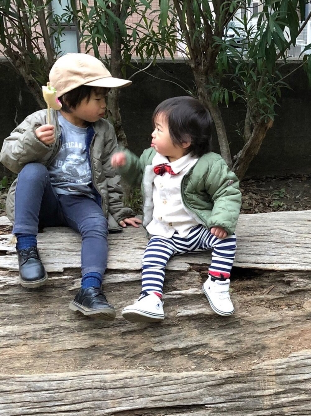 グリーン系のミリタリージャケット、イエロー系のミリタリージャケット、ブラック系のドレスシューズを着用したキッズの春コーディネートの1枚目の写真