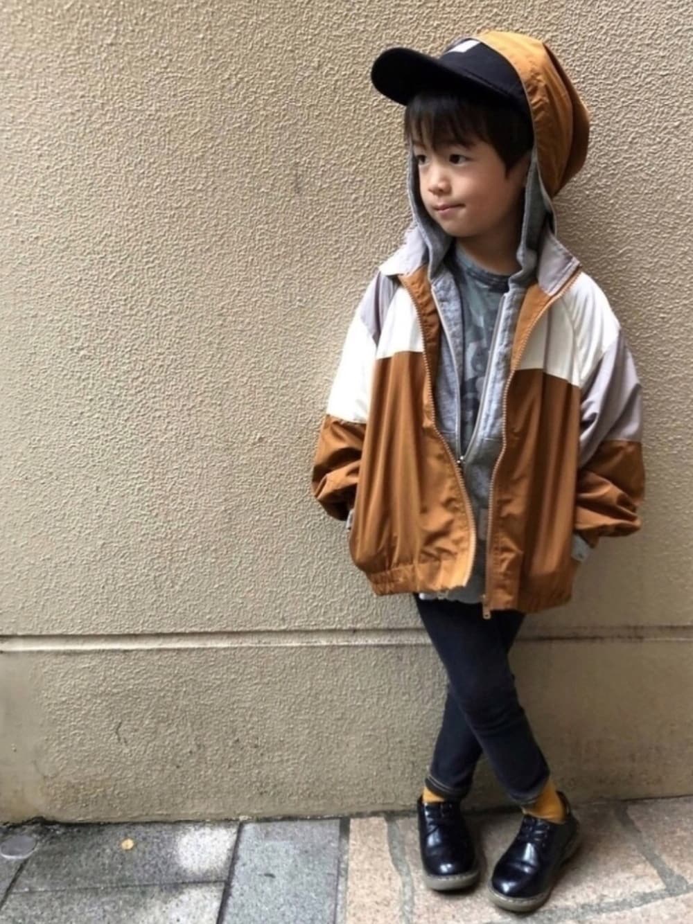 グレー系のパーカー、ブラック系のドレスシューズ、グリーン系のTシャツ/カットソーを着用したキッズの秋コーディネートの1枚目の写真