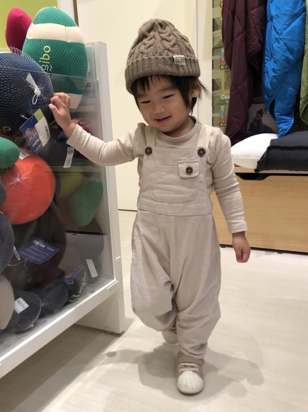 ホワイト系のサロペット/オーバーオール、ベージュ系のTシャツ/カットソー、ベージュ系のスニーカーを着用したキッズの冬コーディネートの1枚目の写真