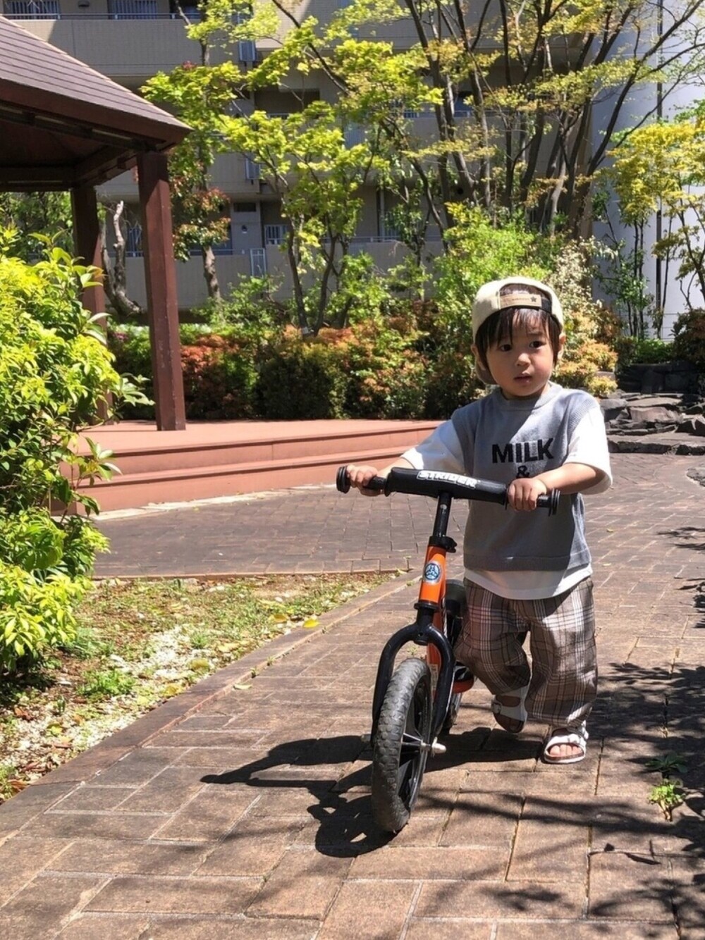 グレー系のTシャツ/カットソー、ブラウン系のその他パンツ、ホワイト系のサンダルを着用したキッズの春コーディネートの1枚目の写真