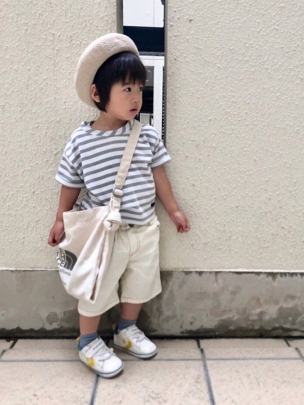 グレー系のTシャツ/カットソー、ホワイト系のデニムパンツ、グレー系のトートバッグを着用したキッズの夏コーディネートの1枚目の写真