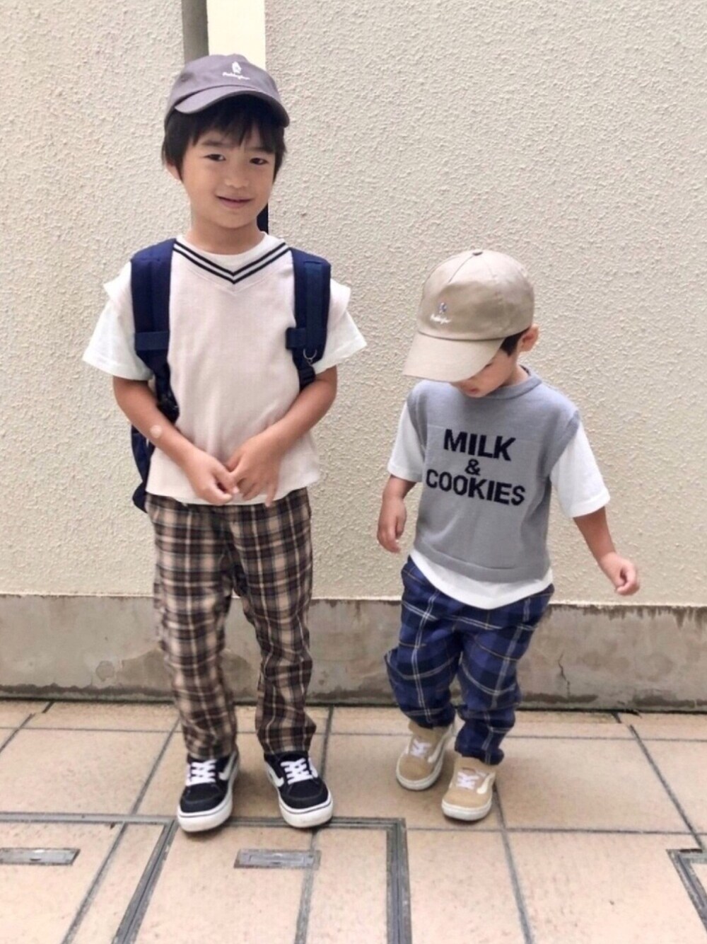 ホワイト系のベスト、グレー系のTシャツ/カットソー、ブラウン系のパンツを着用したキッズの秋コーディネートの1枚目の写真