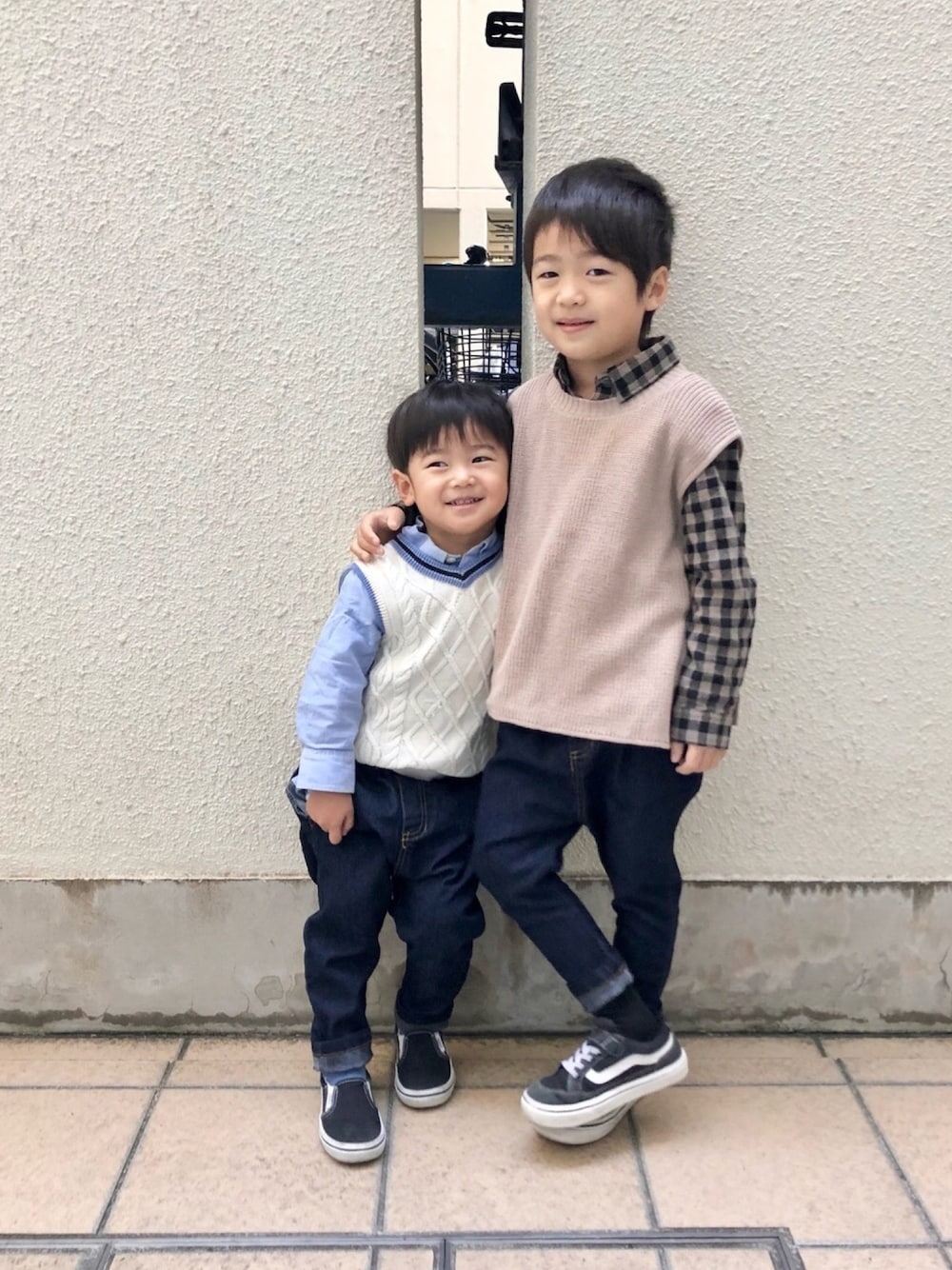 ホワイト系のベスト、ブルー系のシャツ/ブラウス、ブルー系のデニムパンツを着用したキッズの冬コーディネートの1枚目の写真