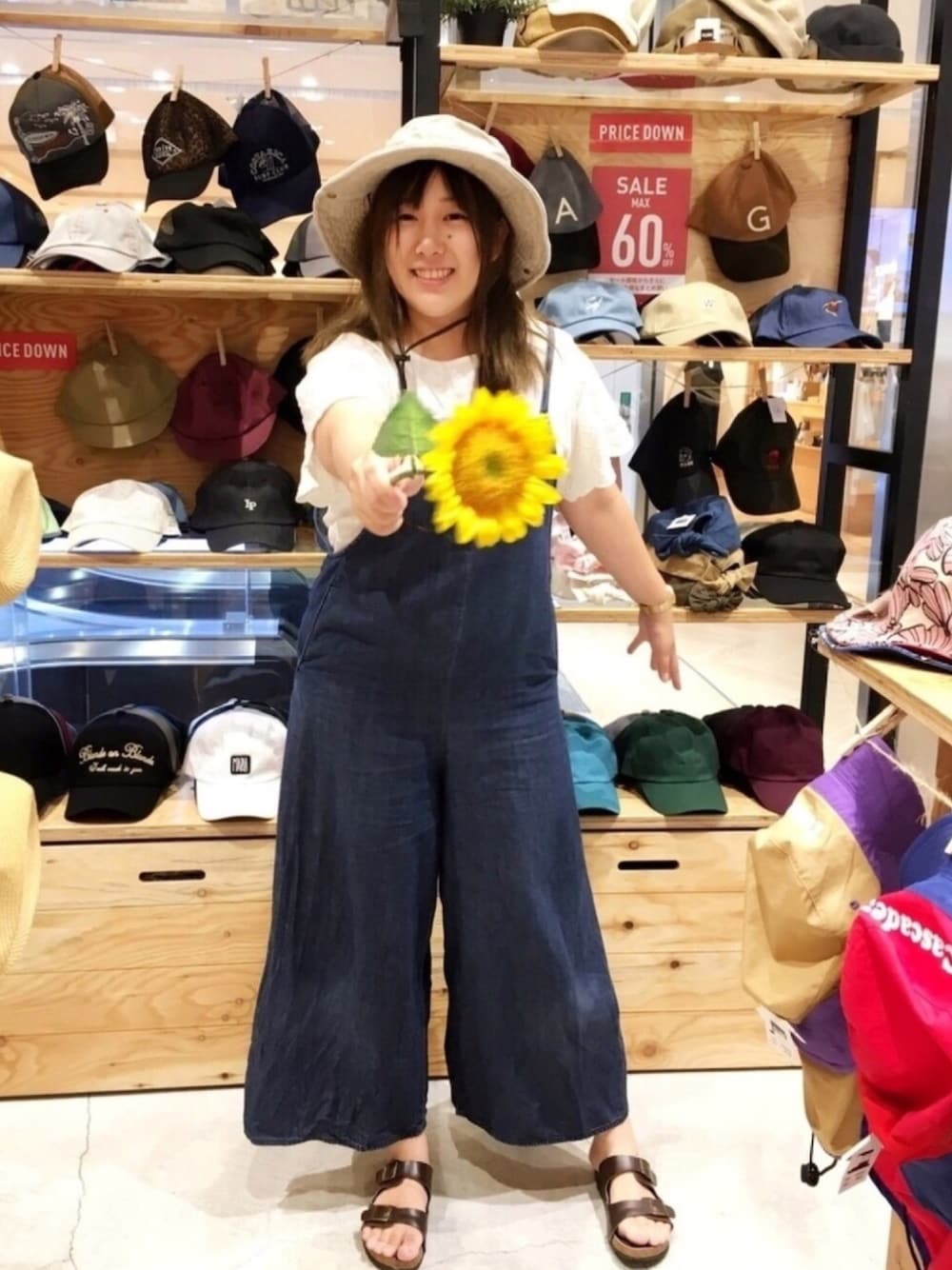 ブルー系のサロペット/オーバーオール、ホワイト系のシャツ/ブラウス、ブラウン系のサンダルを着用したレディースの夏コーディネートの1枚目の写真