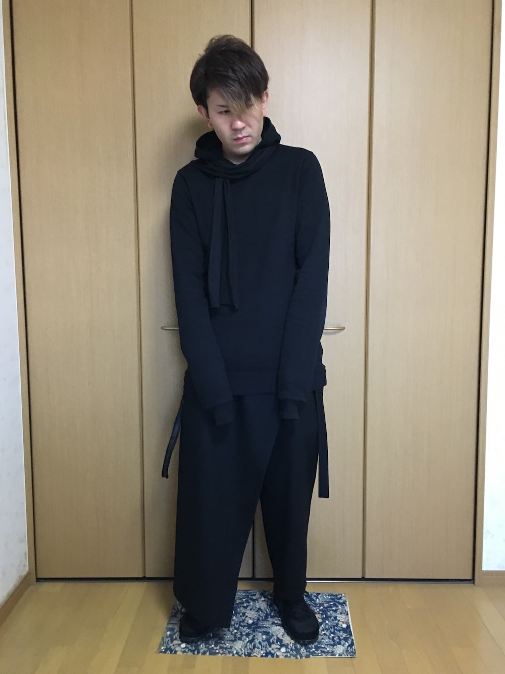 ブラック系のパーカー、ブラック系のパンツ、ブラック系のスニーカーを着用したメンズの秋コーディネートの1枚目の写真