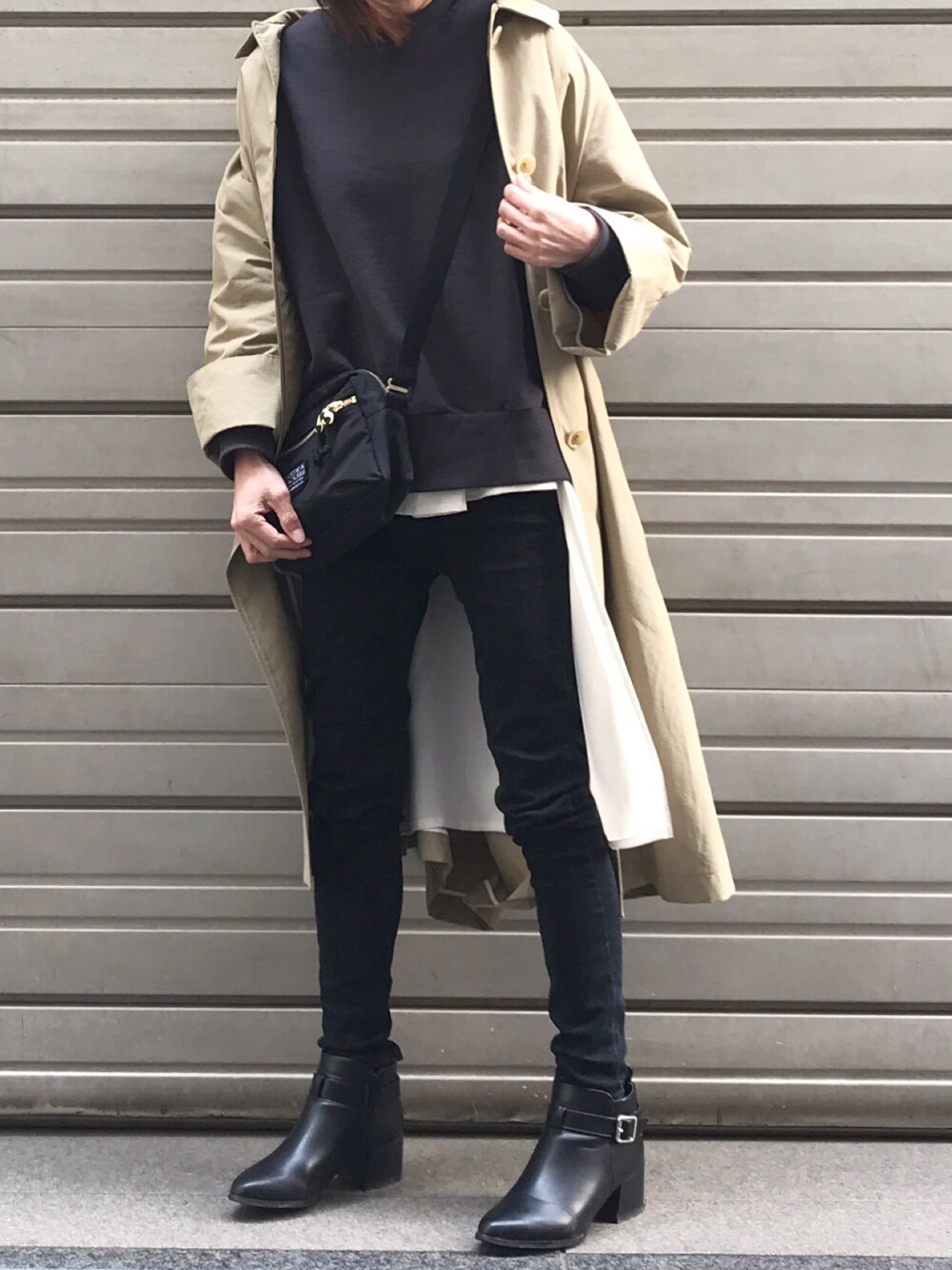 ベージュ系のステンカラーコート、ブラック系のスウェット、ホワイト系のシャツ/ブラウスを着用したレディースの春コーディネートの1枚目の写真