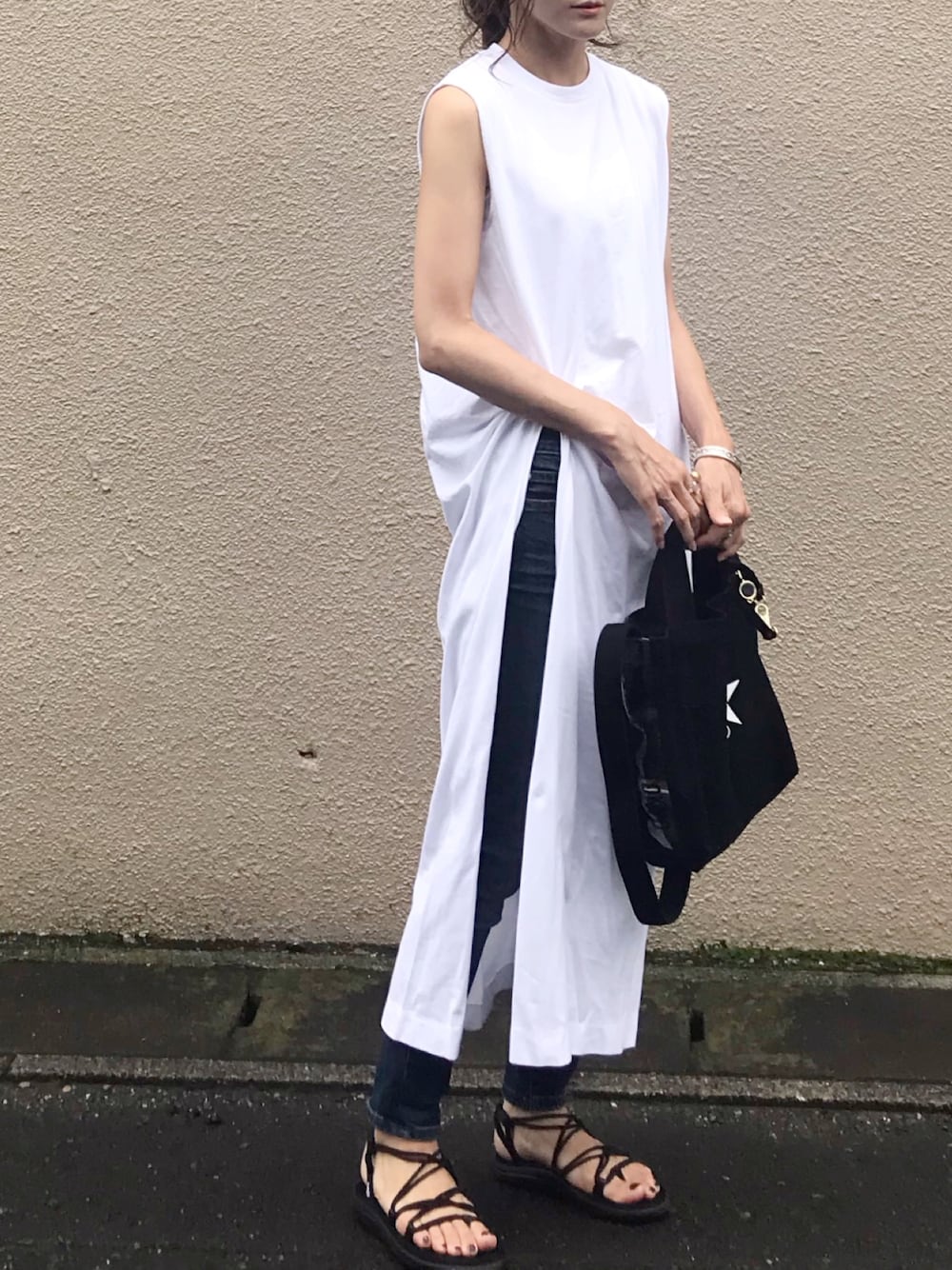 ホワイト系のワンピース、ブルー系のデニムパンツ、ブラック系のトートバッグを着用したレディースの夏コーディネートの1枚目の写真