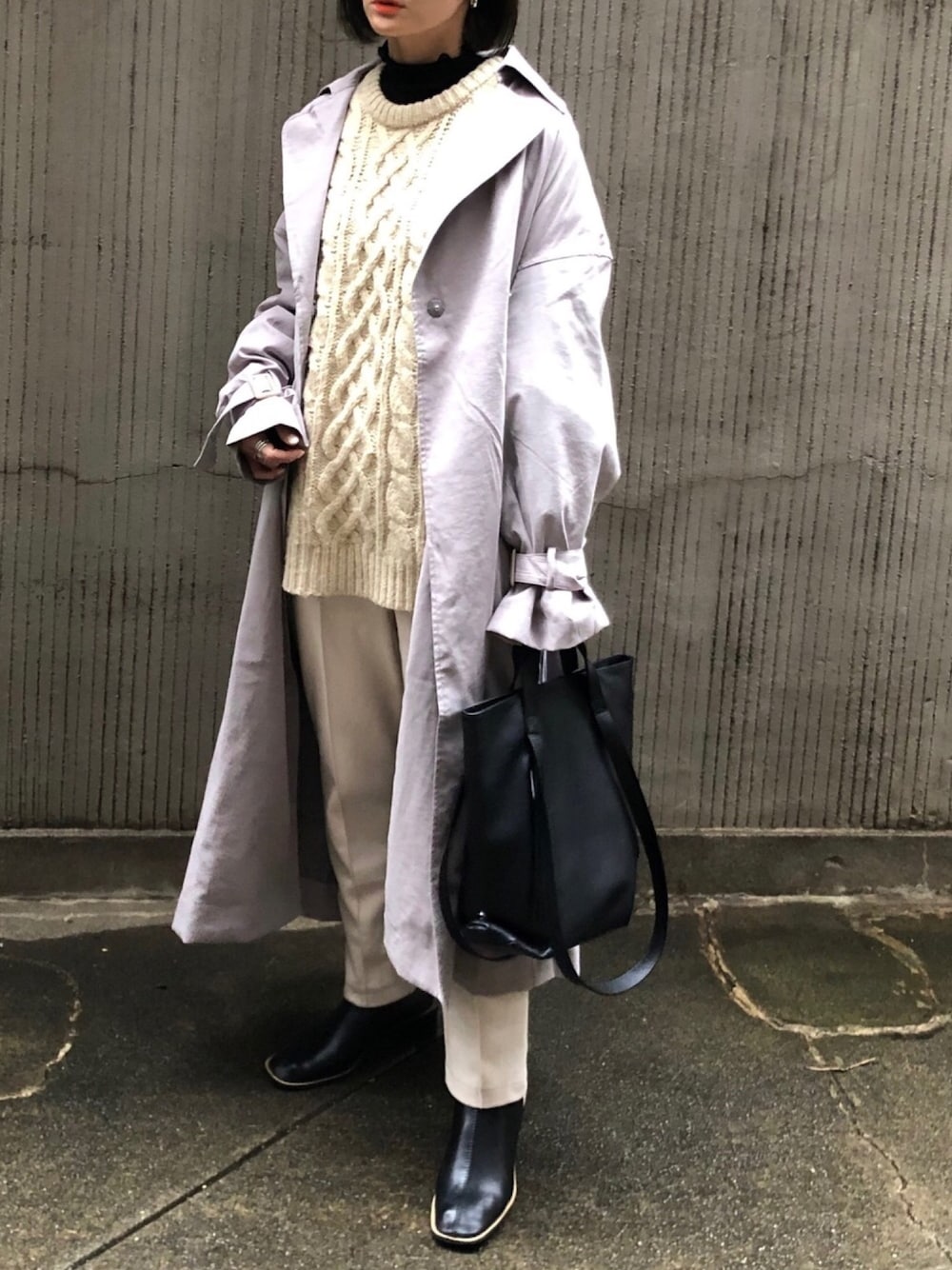 ブラウン系のトレンチコート、ブラック系のTシャツ/カットソー、ベージュ系のニット/セーターを着用したレディースの冬コーディネートの1枚目の写真