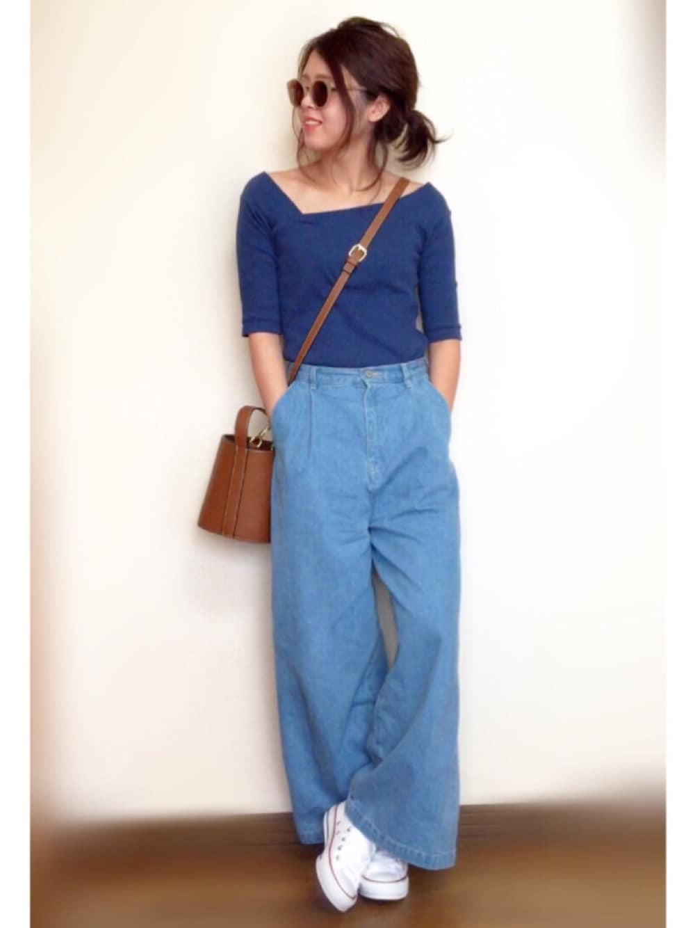 ブルー系のTシャツ/カットソー、ブルー系のデニムパンツ、ホワイト系のスニーカーを着用したレディースの春コーディネートの1枚目の写真