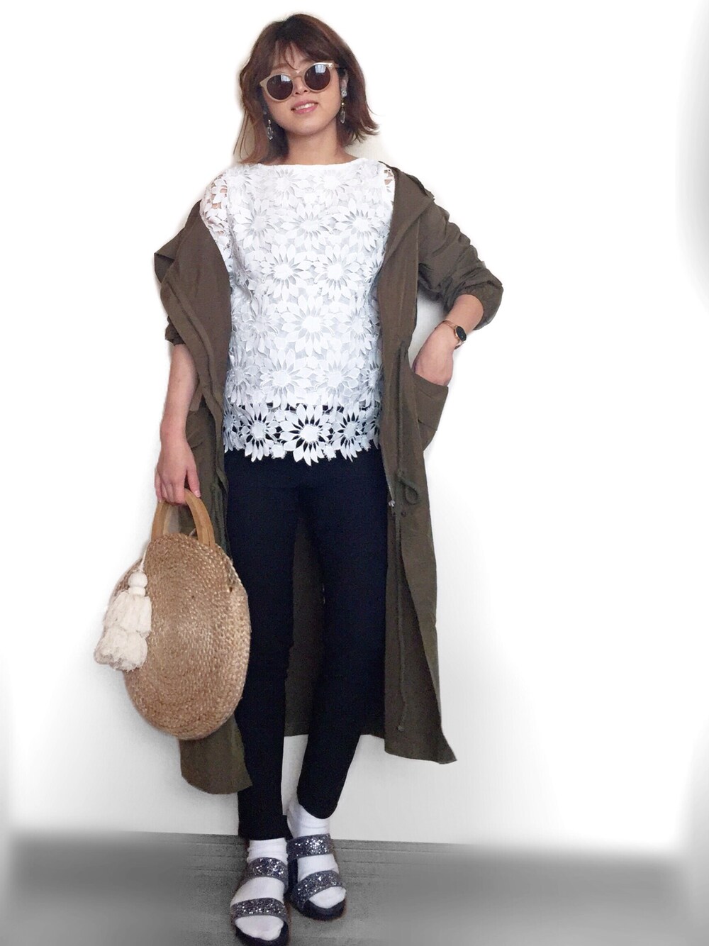 グレー系のサンダル、グリーン系のマウンテンパーカー、ホワイト系のシャツ/ブラウスを着用したレディースの春コーディネートの1枚目の写真