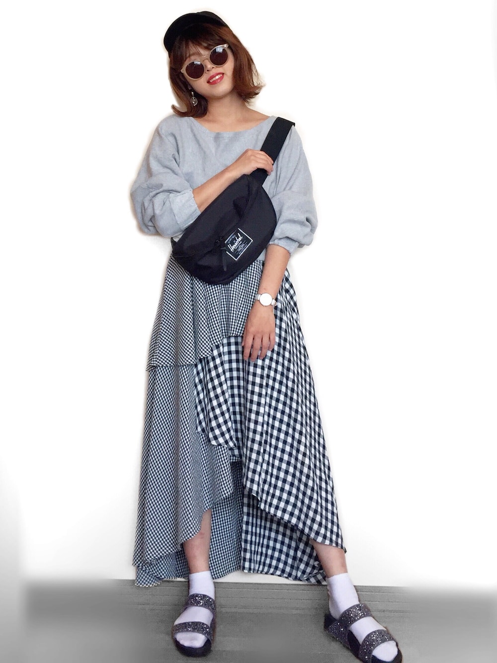 グレー系のサンダル、ブラック系のスカート、グレー系のスウェットを着用したレディースの春コーディネートの1枚目の写真