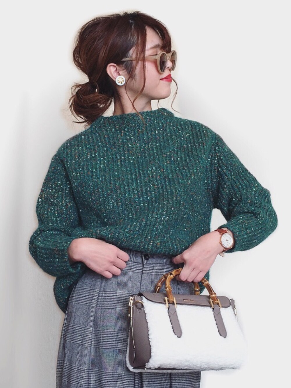 グリーン系のニット/セーター、グレー系のパンツ、ホワイト系のショルダーバッグを着用したレディースの冬コーディネートの1枚目の写真