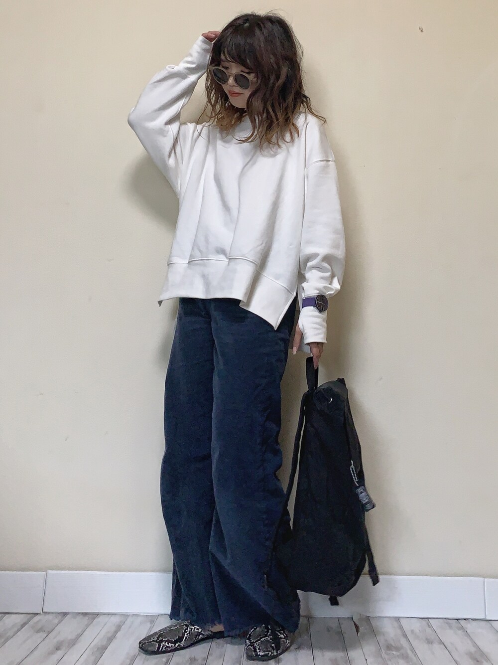 ホワイト系のスウェット、ブラック系のバックパック/リュック、パープル系のアナログ腕時計を着用したレディースの秋コーディネートの1枚目の写真