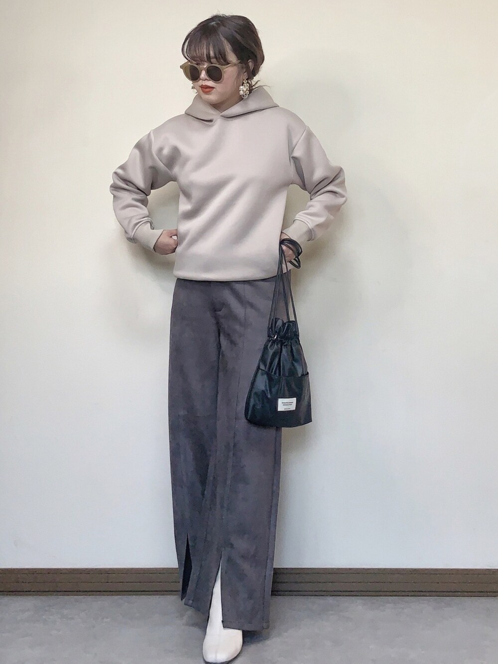 グレー系のその他パンツ、ブラック系のショルダーバッグ、ベージュ系のTシャツ/カットソーを着用したレディースの冬コーディネートの1枚目の写真