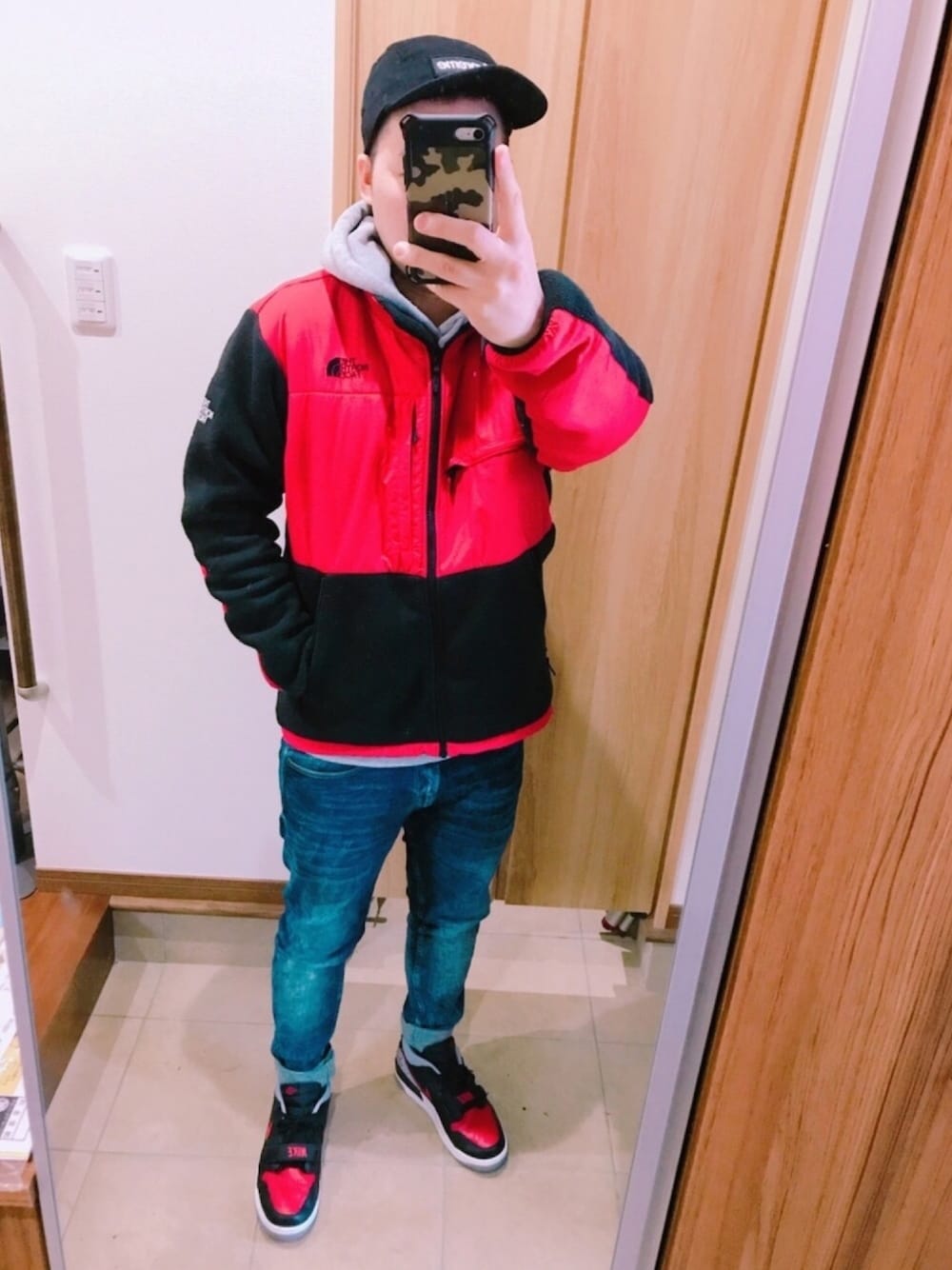 レッド系のブルゾン、グレー系のパーカー、ブラック系のTシャツ/カットソーを着用したメンズの冬コーディネートの1枚目の写真