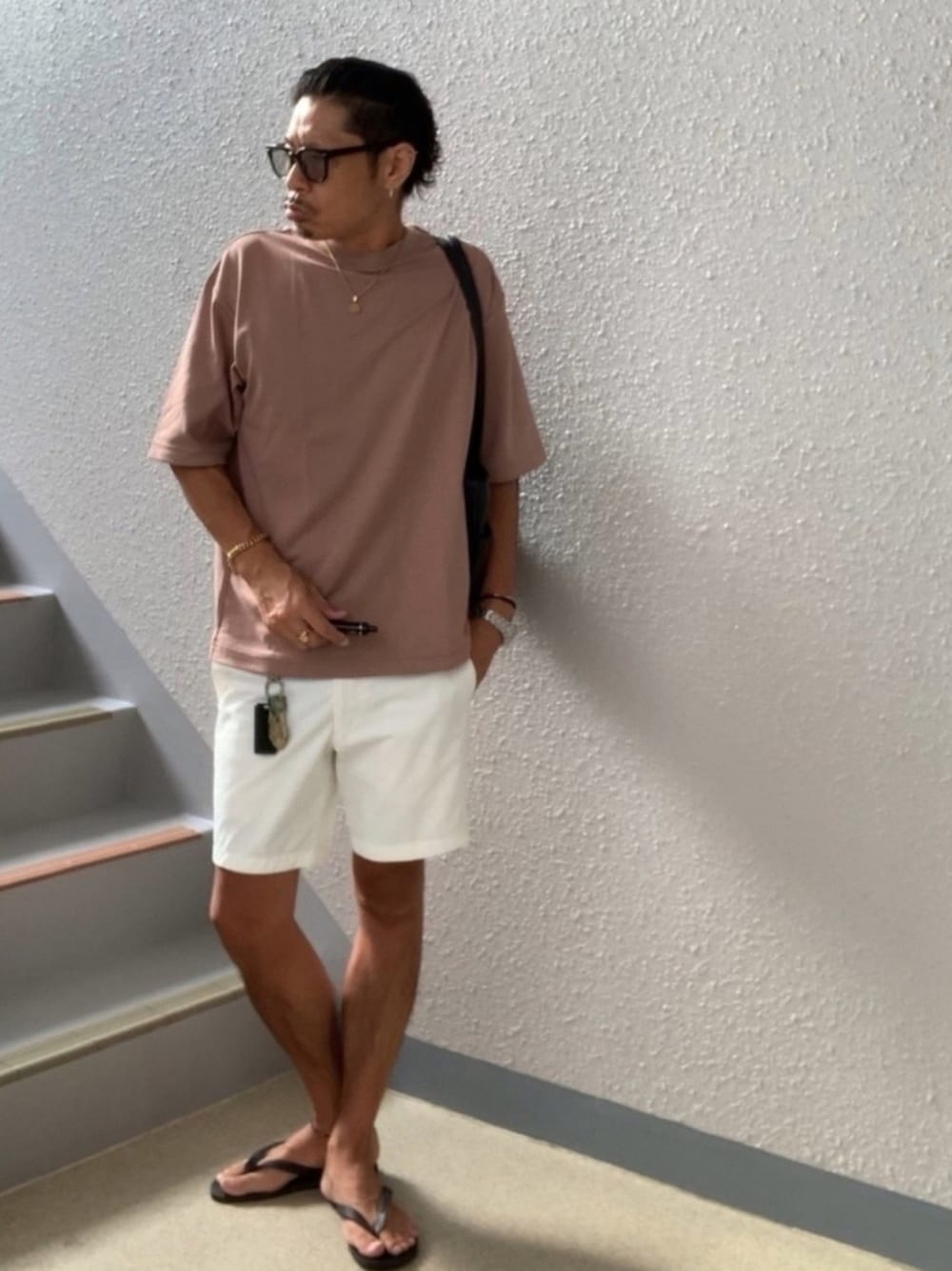 ブラウン系のTシャツ/カットソー、ホワイト系のその他パンツ、ブラック系のビーチサンダルを着用したメンズの夏コーディネートの1枚目の写真
